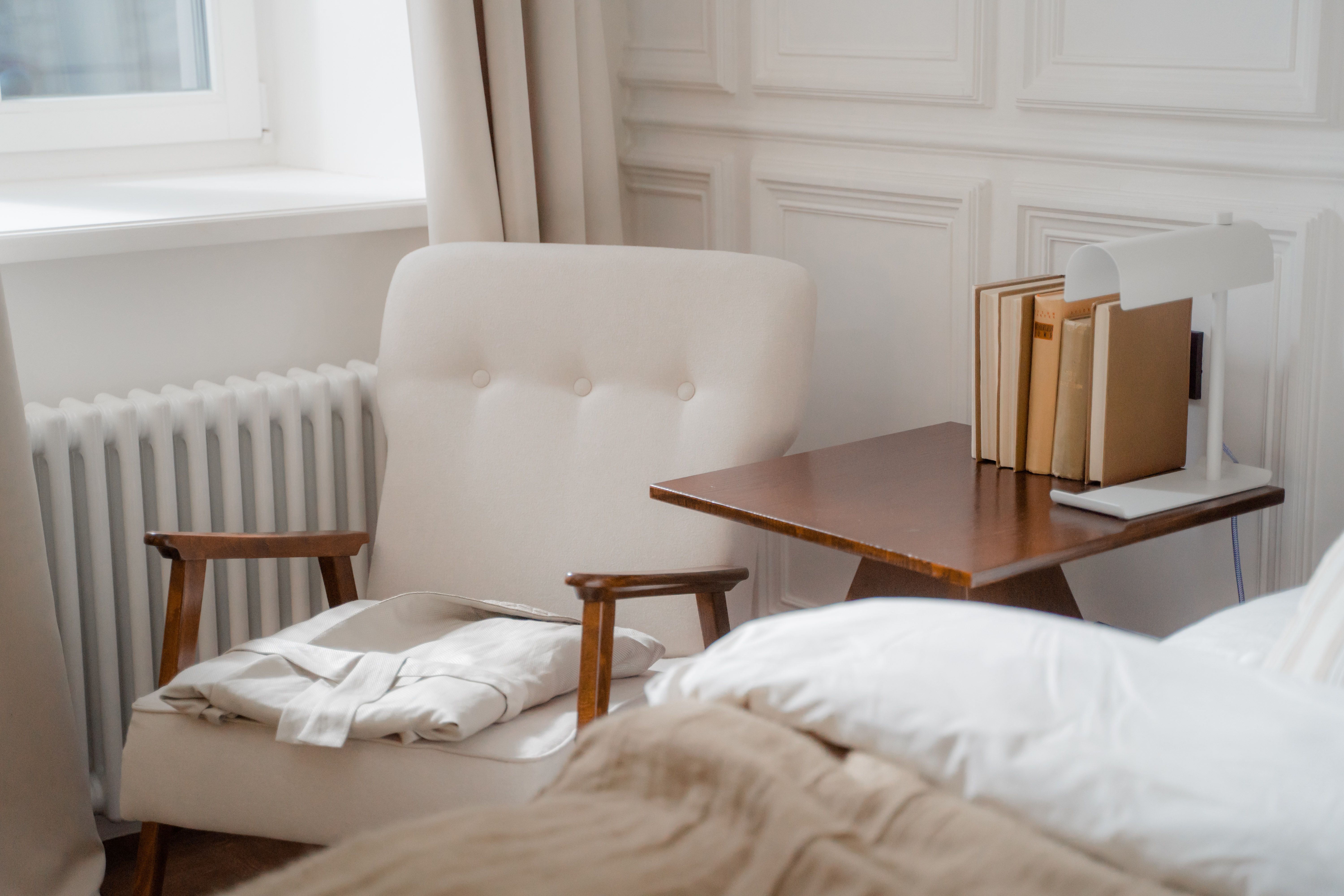 Un fauteuil, des livres et un peignoir près de la fenêtre