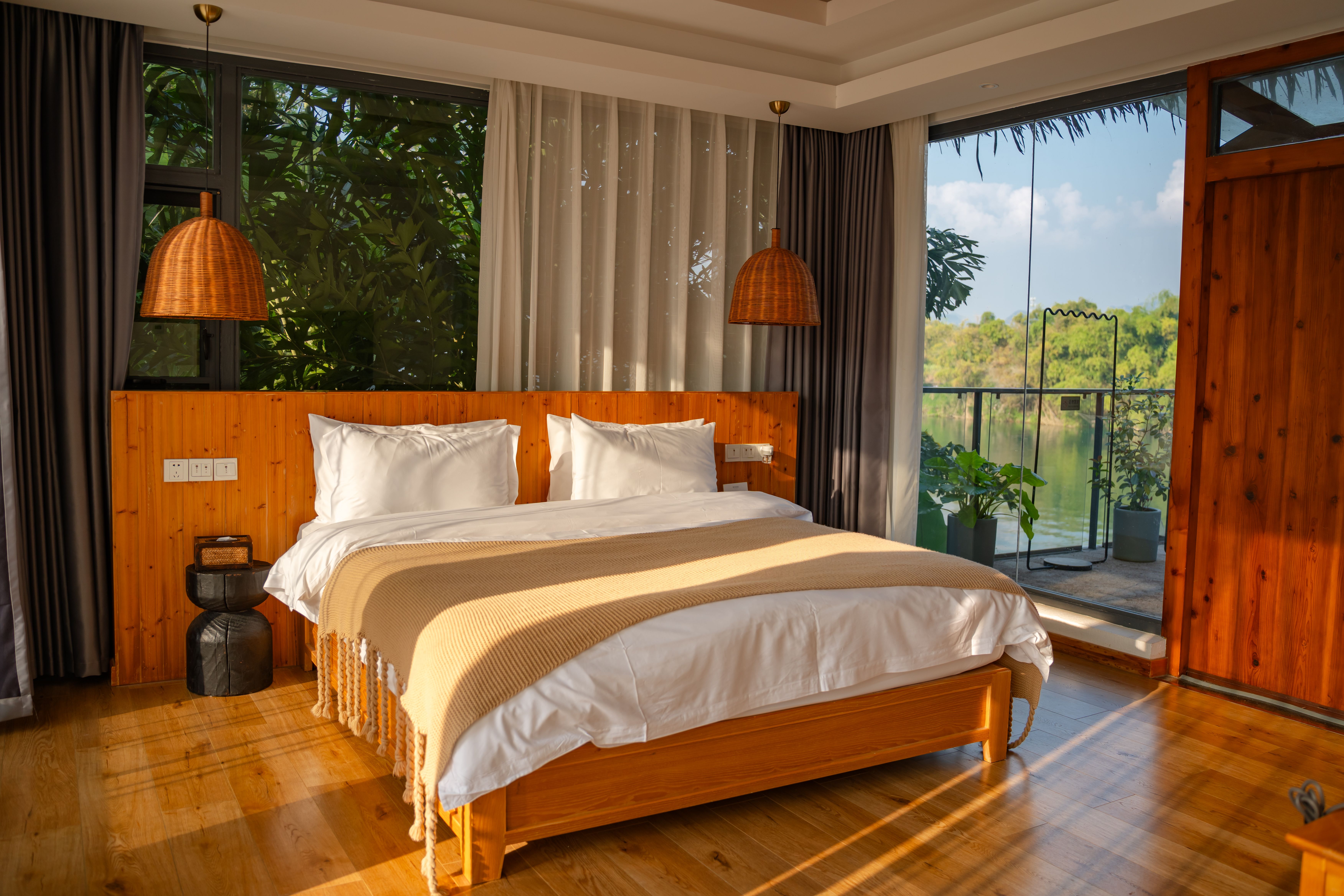 Chambre Jardin : lit double, parquet et bois clair, grandes fenêtres sur la verdure